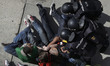 A riot police officer grabs the face of a member of the Victims' Mortgage Platform (PAH) a...