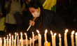 Tibetans living in India place candle and gather along with others for a candlelight vigil...