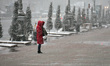 KYIV, UKRAINE - MARCH 12, 2023 - A woman in a red puffer coat talks on the phone as it is...