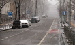 KYIV, UKRAINE - MARCH 12, 2023 - Cars are parked on a street as it is snowing in early spr...