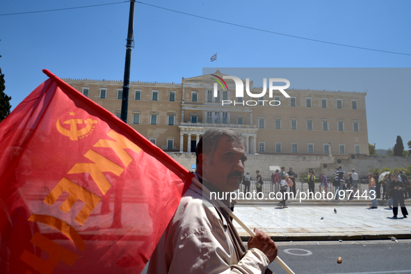 A communist protester holds the flag of the Greek Communist Party in front of the Greek Parliament in central Athens, on May 1, 2014. 