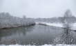 Snow covered landscape with the lake and building around in Park Meerland. Blizzard hits t...