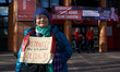 A retired woman with a placard reading 'Retired and more than ever supporter' in front of...