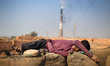 Brickyard worker is taking a shot nap during work.The world is going through a speedy urb...