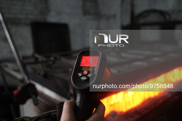 KHARKIV, UKRAINE - MARCH 16, 2023 - A person holds a pyrometer to control the temperature of surface hardening of ballistic plates at the Uk...