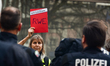 

A protester is holding a sign of ''Climate Red Car of RWE'' in front of several police o...
