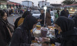Iranian women shop nuts from a vendor at a local outdoor bazaar (Market) near a holy shrin...
