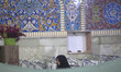 A veiled Iranian worshipper waits to take part in an evening mass prayer ceremony in a hol...