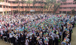 Students posing for the camera showing their new books standing at the assembly inside a s...