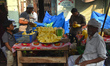 People are cutting pineapple for selling on a roadside food stall during the holy month of...