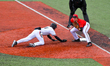 Cincinnati pitcher, Landyn Vidourek, is seen diving back to first base during a college ba...