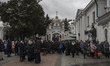 Believers and priest of Ukrainian Orthodox Church (Moscow Patriarchate) pray outside a chu...