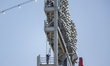Pyrotechnics workers lower equipment from a light stand after setting off fireworks at Nat...
