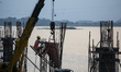 Construction workers busy build pillars of a bridge in the banks of Brahmaputra river on A...
