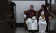 Two members of the Cofradia de la Salud wait to participate in the Holy Week processions t...