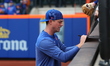 New York Mets relief pitcher Brooks Raley (25) sign for fans before the baseball game agai...