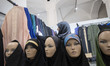 A veiled Iranian woman looks at dresses while shopping at the Imam Khomeini Grand mosque i...