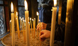 A man lights a candle on Good Friday in the church of Agios Eleftherios in Thessaloniki, G...