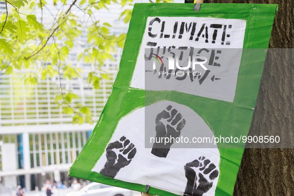 A sign rests on a tree during a "World Bank Action Day: Ajay Banga, Get Out Of Fossil Fuels!" protest outside of the 2023 IMF-World Bank mee...