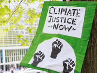 A sign rests on a tree during a "World Bank Action Day: Ajay Banga, Get Out Of Fossil Fuels!" protest outside of the 2023 IMF-World Bank mee...