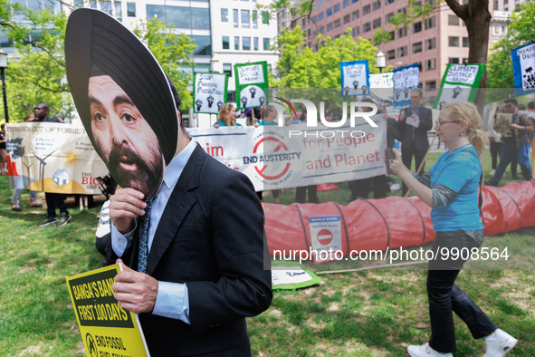 A man wears a mask of incoming World Bank President Ajay Banga during a "World Bank Action Day: Ajay Banga, Get Out Of Fossil Fuels!" protes...
