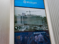 Climate change demonstrators are reflected in a sign on the World Bank buildling in Washington, D.C. on April 14, 2023 as demonstrators stag...