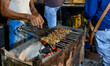 Chefs are seen preparing various kababs on a charcoal flame ahead of iftar time at a marke...