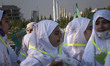 Veiled Iranian schoolgirls stand together under Iranian-made surface-to-surface missiles a...