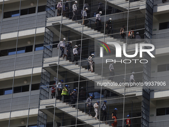 A group of people descend from a building down a flight of stairs during the First National Drill 2023 in Mexico. (