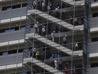 A group of people descend from a building down a flight of stairs during the First National Drill 2023 in Mexico. (
