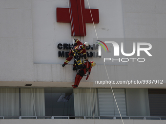 A member of the Mexican Red Cross in Mexico City rappels down during the First National Drill 2023 in Mexico, on april 19, 2023, where they...